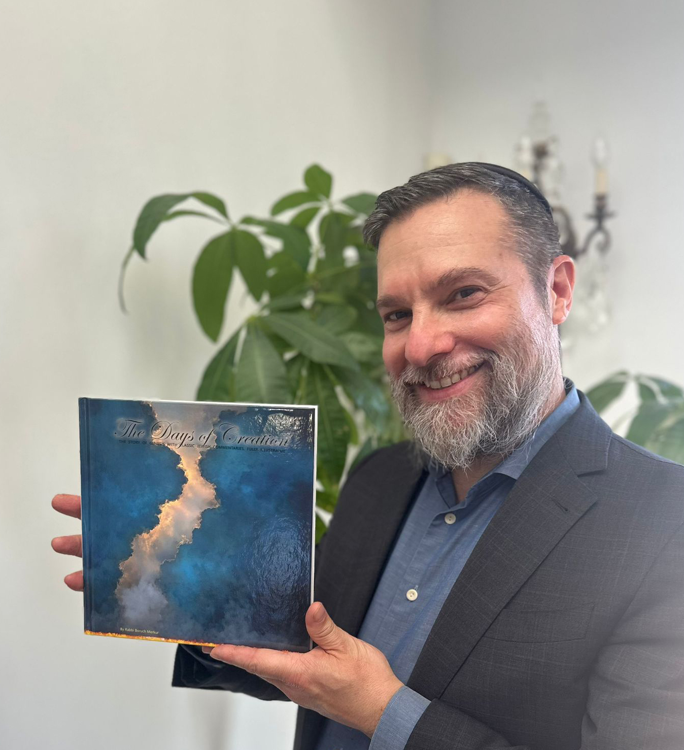 Rabbi Boruch Merkur holding The Days of Creation